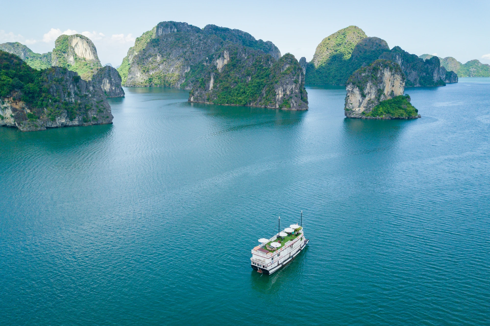 Day cruise boat among limestone islands on Lan Ha Bay, photographed from above